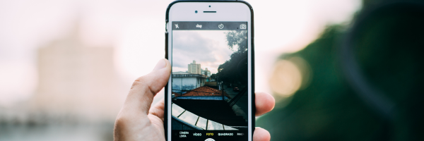 image of a phone showing a video of a car driving in front of them